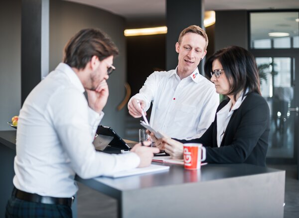 Arbeitsumfeld Büro | © IGP Pulvertechnik AG 3 Mitarbeitende der IGP Pulvertechnik AG besprechen das Training für die Pulverlackindustrie | © IGP Pulvertechnik AG