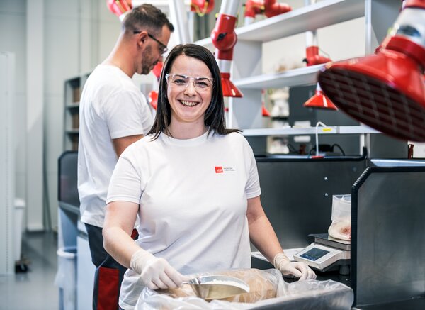 Arbeitsumfeld: Mitarbeiterin Technologie | © IGP Pulvertechnik AG Mitarbeiterin der IGP Pulvertechnik AG zeigt Rohstoff für Pulverlacke | © IGP Pulvertechnik AG