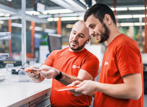 Arbeitsumfeld Produktion | © IGP Pulvertechnik AG Zwei Mitarbeitende der IGP Pulvertechnik AG unterhalten sich über Pulverlacke | © IGP Pulvertechnik AG