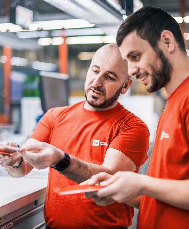 Arbeitsumfeld Produktion | © IGP Pulvertechnik AG Zwei Mitarbeitende der IGP Pulvertechnik AG unterhalten sich über Pulverlacke | © IGP Pulvertechnik AG